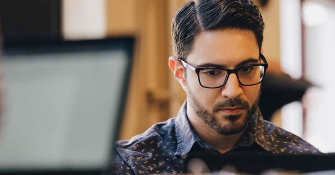 Man with glasses looking at screen